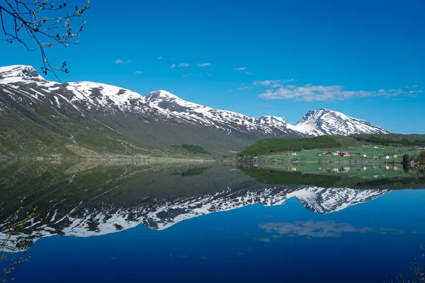 Noruega hermoso paisaje de primavera. Reflexión de las montañas en aguas tranquilas de fiordo Fotos de stock libres de derechos