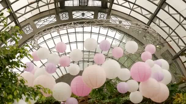 White pink balls of rice paper hanging on the branches of green trees Stock Video