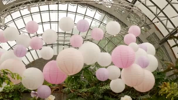 White pink balls of rice paper hanging on the branches of green trees Stock Footage