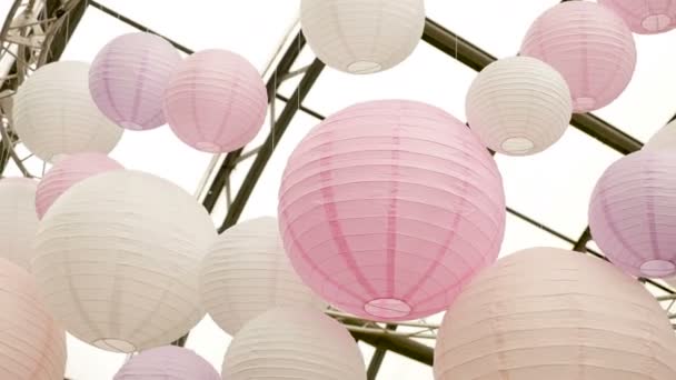 White pink balls of rice paper hanging on the branches of green trees Stock Video