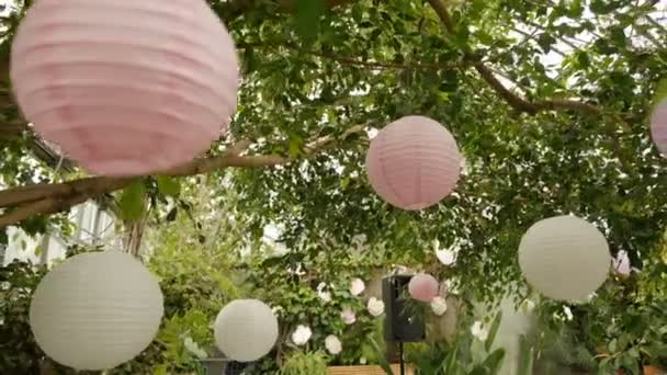 White pink balls of rice paper hanging on the branches of green trees Video Clip