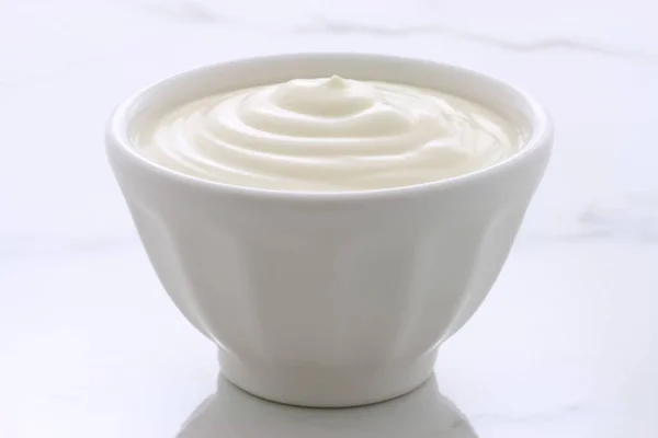 Delicious, nutritious and healthy fresh plain yogurt on vintage italian carrara marble setting.