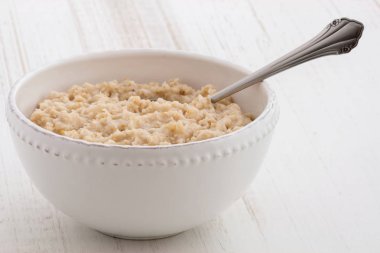 Lezzetli sağlıklı ve besleyici taze eski moda yulaf ezmesi antika ahşap masa üzerinde