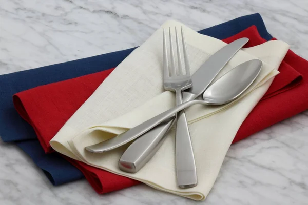 silverware and hemstitch napkin on antique carrara marble