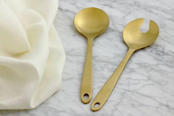 Beautiful golden serving spoon and fork Royalty Free Stock Photos