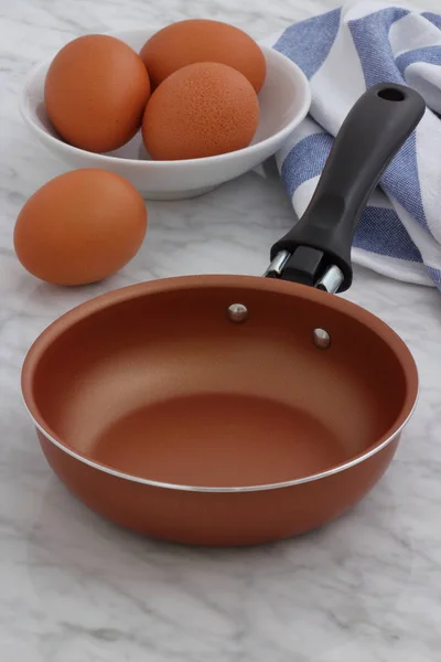 Frying pan and eggs on kitchen counter — Stock Photo, Image