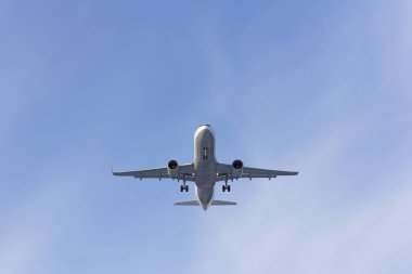 Uçak beyaz bulut bir arka plan karşı uçar