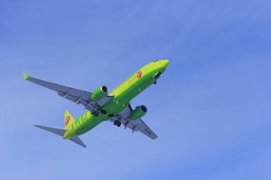 Uçak beyaz bulut bir arka plan karşı uçar