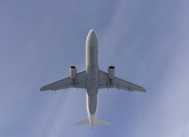 Uçak beyaz bulut bir arka plan karşı uçar