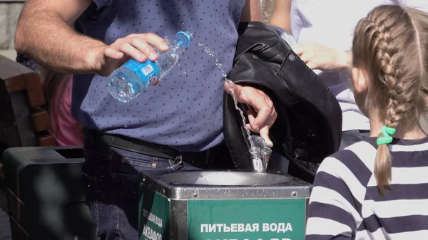 МОСКВА - 24 июля 2019 года: Мужчина собирает воду из фонтана в бутылке для питья 24 июля 2019 года в Москве, Россия — стоковое фото