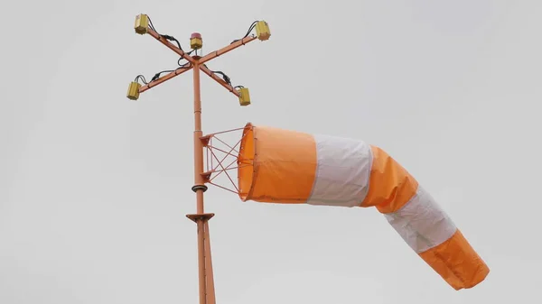 Frayed windsock in moderate wind against blue sky — Stock Photo, Image