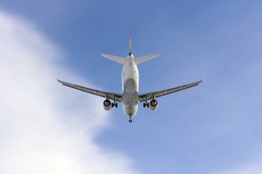Uçak beyaz bulut bir arka plan karşı uçar