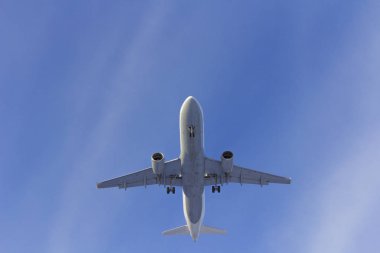 Uçak beyaz bulut bir arka plan karşı uçar