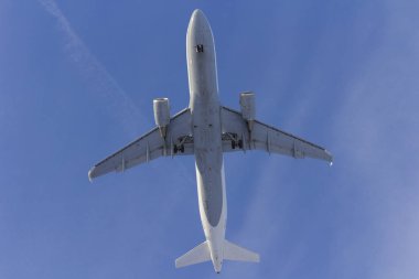 Uçak beyaz bulut bir arka plan karşı uçar