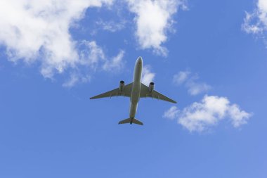 Uçak beyaz bulut bir arka plan karşı uçar