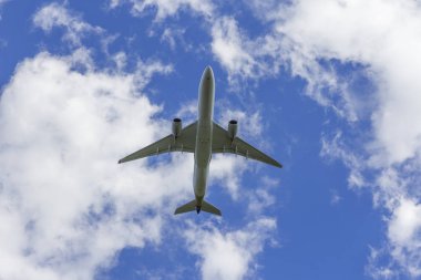 Uçak beyaz bulut bir arka plan karşı uçar