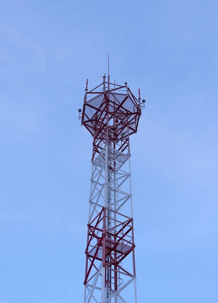Telekommunikációs torony antennákkal a kék skyand fehér felhő háttérrel — Stock Fotó