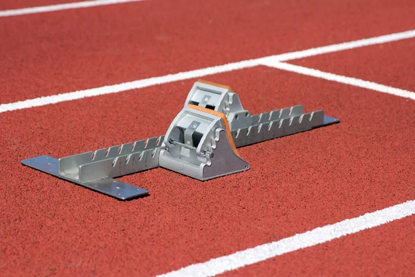 Athletics starting blocks on race red track — Stock Photo, Image