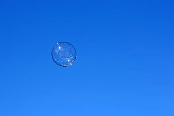 Zeepbel die tegen de blauwe lucht vliegt — Stockfoto