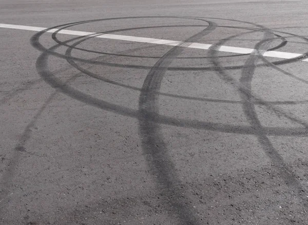 Sendero negro de neumáticos de goma en el asfalto — Foto de Stock