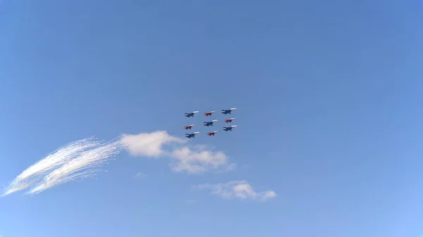 Kampfflugzeuge su-35 (flanker-e) und mig-29 (Drehpunkt) gesäumte Diamantfliege mit Feuerwerk fliegen in den Himmel — Stockfoto