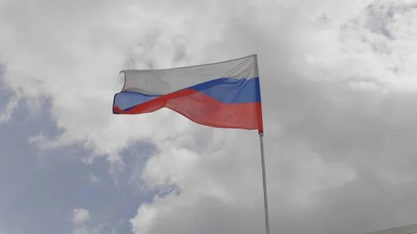 Rosyjska Flaga na maszcie machając w wiatr przed błękitne niebo z chmur. Zwolnionym — Zdjęcie stockowe