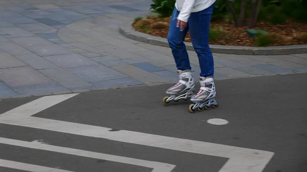 Voeten van meisje rijden op een rolschaatsen rit op asfalt. — Stockfoto