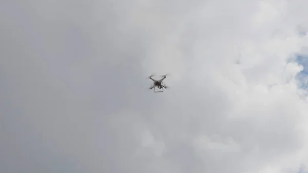 Latający dron helikoptera na tle białych chmur — Zdjęcie stockowe