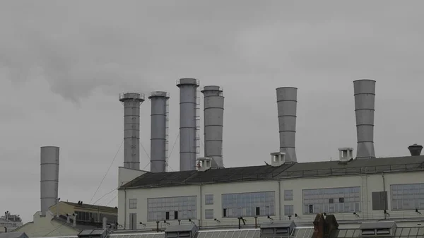 Tuyaux avec fumée dans un bâtiment d'usine — Photo