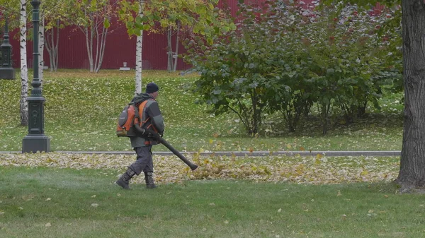 Working blows autumn leaves vacuum blower — Stock Photo, Image