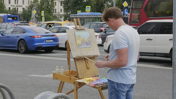 MOSCOW - AGOSTO 26: Artista de rua pinta paisagem urbana em 26 de agosto de 2017 em Moscou, Rússia . — Fotografia de Stock