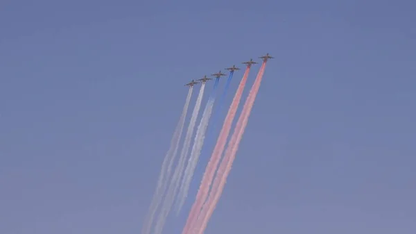 Aerei truppe d'assalto Su-25 sventolano in cielo lasciando tracce di fumo come bandiera tricolore russa sulla parata di formazione in onore della grande vittoria della guerra patriottica il maggio — Foto Stock