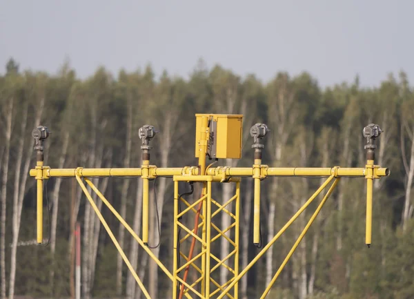 노란색 금속 지원 시스템 이 이 륙 및 착륙 방향등을 활주로 근처에 설치하는 동안 — 스톡 사진