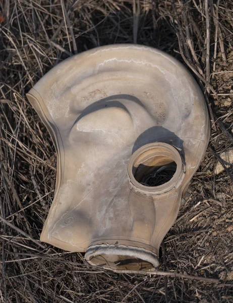 Una vieja máscara de gas yace en un campo en el suelo — Foto de Stock