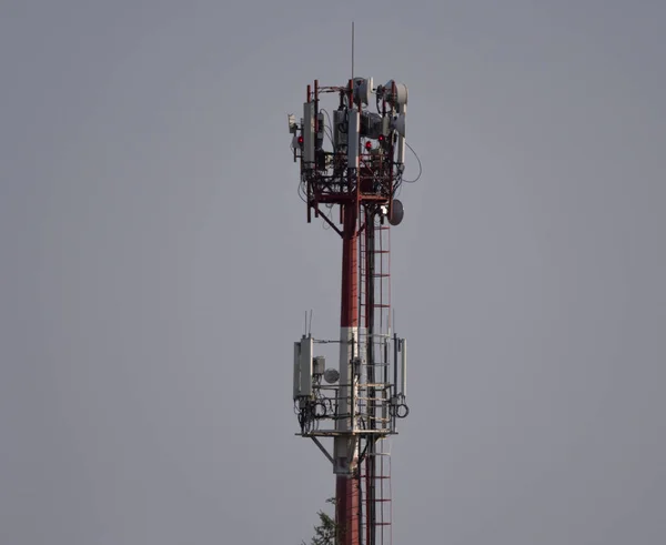 Telekommunikation står hög med antenner mot med blått himlenoch vit moln bakgrund — Stockfoto