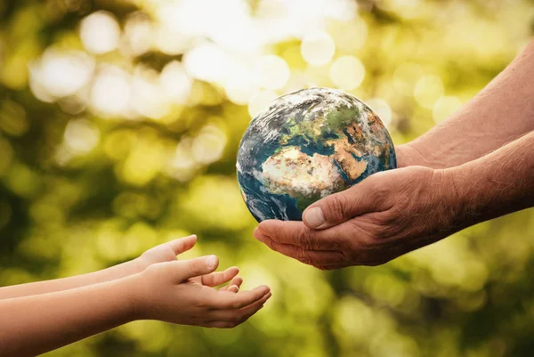 Close Senior Hands Giving Small Planet Earth Child Defocused Green — Stock Photo, Image