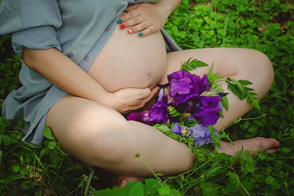 Mujer Embarazada Vientre. Concepto de embarazo. Sobre la naturaleza verde borrosa Fondo. Embarazada barriga de cerca . —  Fotos de Stock