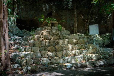 Ormanda bir tabelaolan küçük bir piramit. Gün ışığı.