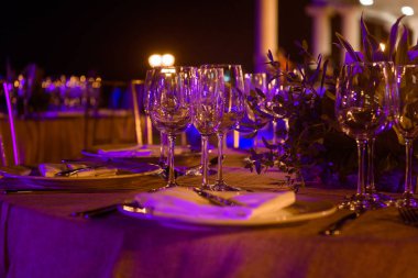 Ziyafette mor tonlarda servis edilen masalar. Gece fotoğrafı.