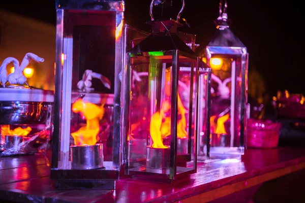 Üveg lámpák valódi tűz belsejében lila tónusok. Éjjeli fénykép. — Stock Fotó