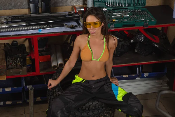 Sexy girl in garage with bike tires