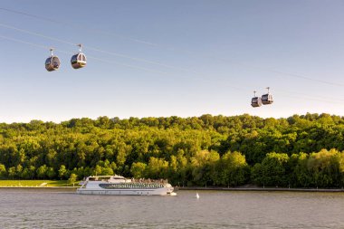 Moskova Nehri, Moskova, Rusya turist tekne yüzer. Teleferik serçe tepeleri ve Moskova'da Lujniki Stadyumu arasında doğal görünümünü. Moskova Luzhniki Park gökyüzünde teleferik kabinleri asmak.