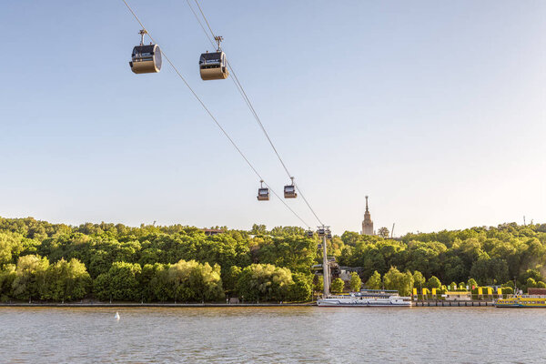 Scenic view of the cable car between Sparrow Hills and Luzhniki Stadium in Moscow, Russia. Cableway cabins hang in the sky above Moskva River in Moscow. Luzhniki park is a sport landmark of Moscow.