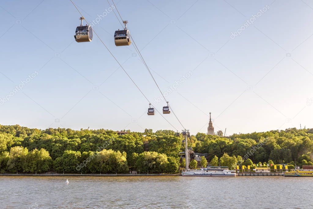 Scenic view of the cable car between Sparrow Hills and Luzhniki Stadium in Moscow, Russia. Cableway cabins hang in the sky above Moskva River in Moscow. Luzhniki park is a sport landmark of Moscow.