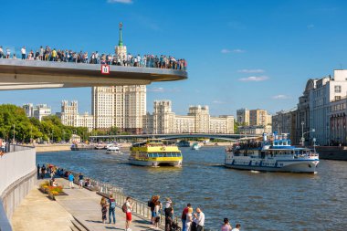 Moskova - 16 Haziran 2018: Turistik gemiler yelken Moskova Nehri üzerinde yüzen köprü Zaryadye Park, Rusya'da geçmiş. Zaryadye Moskova ana yerlerinden biridir. İnsanlar Moskova merkezinde yaz aylarında rahatlamak..