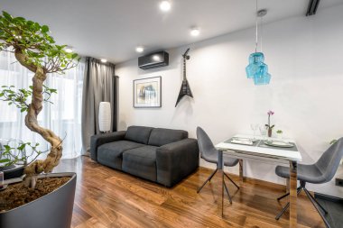 Moskova - 25 Mart 2018: Modern ev iç kanepe, Masa ve bitkiler. Güzel minimalist iç tasarım oturma odası beyaz duvarlı. Lüks doğal ahşap zemin daire iç.