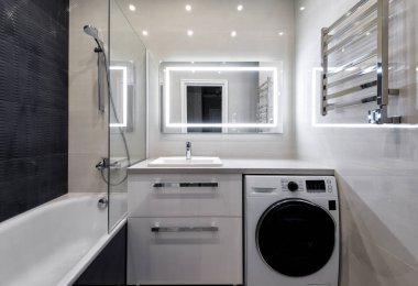 Moskova - 5 Haziran 2018: İç otel ya da konut ev banyo. Açık ve koyu zemin ile iç tasarım. Modern banyo duş, çamaşır makinesi ve Led aydınlatma ayna.