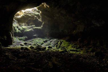 Karanlık mağaranın bir parlak gün ışığı nokta çıkış ile. Doğal mağara Kırım'da açılıyor. Bir dağ karstik mağarada girişi. İçinde yeraltı mağara arka plan kopya alanı ile. 