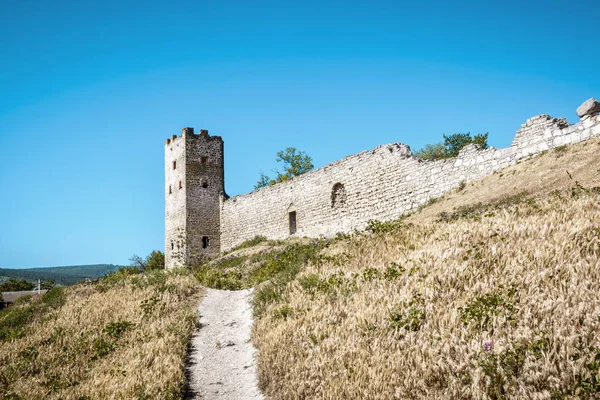 克里米亚 Feodosia 的旧热那亚堡垒 在夏天的道路上的堡垒废墟全景 这是克里米亚历史上的里程碑 山上被毁坏的堡垒的塔和墙壁 — 图库照片