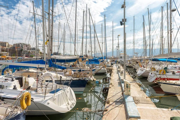 Yachts docked in sea port in Piraeus, Athens, Greece. Modern sailing boats mooring in beautiful marina in summer. Scenic view of nice yachts in harbor. Concept of luxury marine relax and vacation.